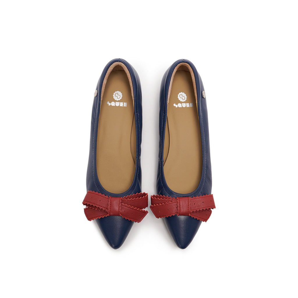 A pair of navy blue leather pointed-toe flats with red bow accents on the front, lambskin, comfortable, stylish