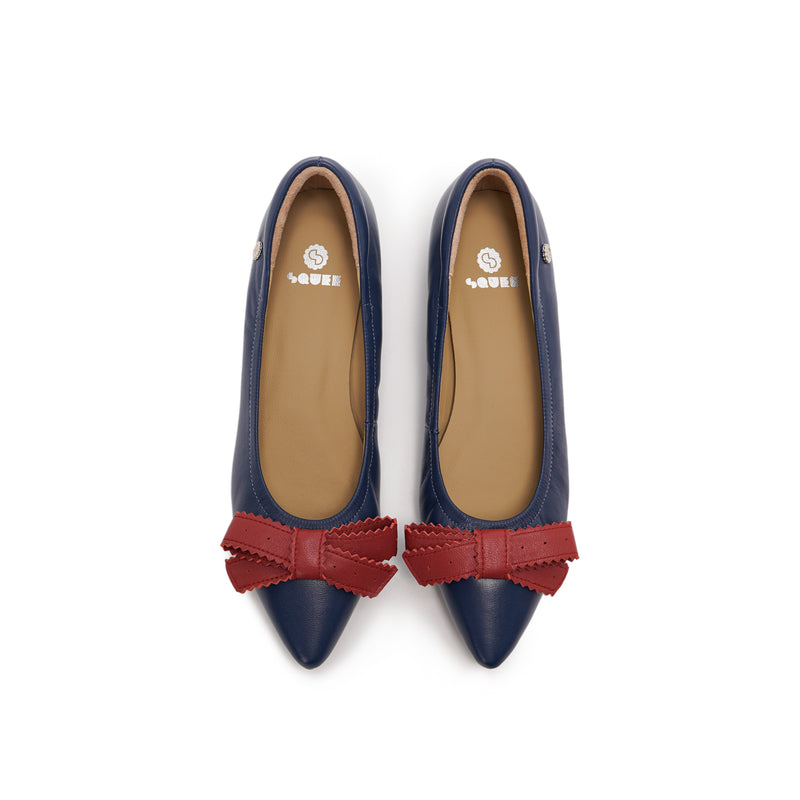 A pair of navy blue leather pointed-toe flats with red bow accents on the front, lambskin, comfortable, stylish