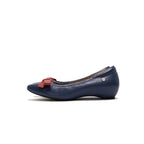 A navy blue leather ballet flat shoe with a small red bow detail on the toe and a small gold squee logo emblem on the side, lambskin, comfortable, stylish